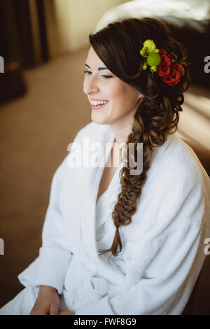 Braut sitzt auf einem Stuhl in weißes Gewand Stockfoto