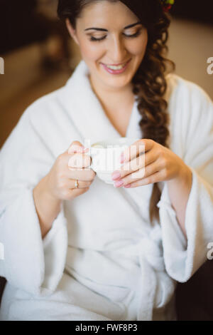 Braut sitzt auf einem Stuhl, Kaffee trinken Stockfoto