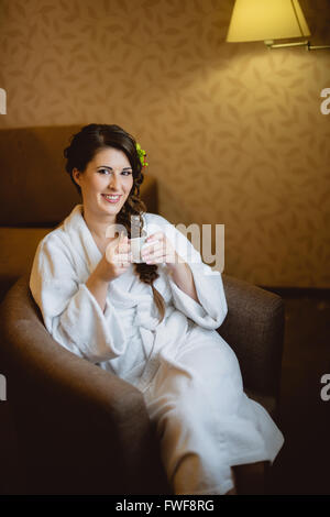 Braut sitzt auf einem Stuhl, Kaffee trinken Stockfoto