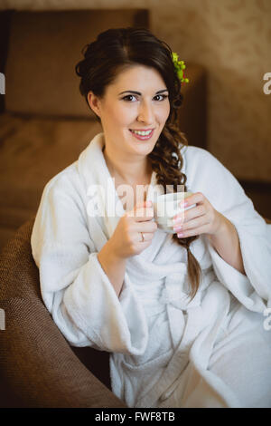 Braut sitzt auf einem Stuhl, Kaffee trinken Stockfoto