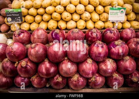 Eine Darstellung der Bio-Kartoffeln und roten Zwiebeln in der Gemüseabteilung ein Lebensmittelgeschäft. Stockfoto