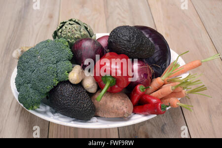Eine Auswahl an frischen Bio-Obst und Gemüse in einer Schüssel auf einer Tischplatte Stockfoto