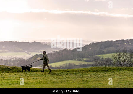 Wenig Solsbury Hill, furnished, Somerset, UK Misty Morning Dogwalker oben auf die alte Festung der Eisenzeit bekannt geworden in dem Lied "Solsbury Hill" von Peter Gabriel. Stockfoto