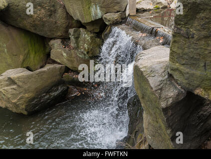 Dam / Wasserfall über Felsblöcke in das Loch im nördlichen Central Park, New York City, New York. Stockfoto