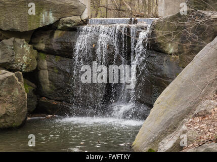 Dam / Wasserfall über Felsblöcke in das Loch im nördlichen Central Park, New York City, New York. Stockfoto