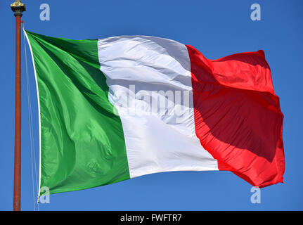 Italienische Fahne flattert im Wind, mit blauem Himmel. Grün, weiß, rot und Azure sind die italienischen Nationalfarben. Stockfoto