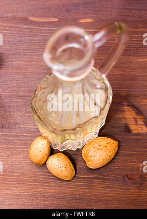Flasche mit Öl Mandeln auf Holztisch von oben gesehen Stockfoto