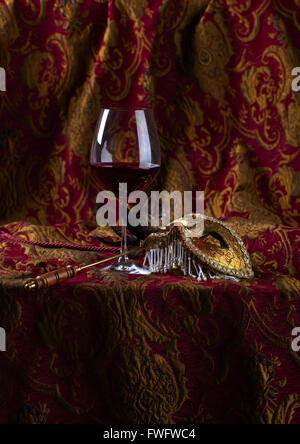 Alte goldene venezianische Maske und Rotwein Stockfoto