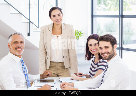 Eine Geschäftsfrau ist im Gespräch mit ihren Kollegen, die ihr hören Stockfoto