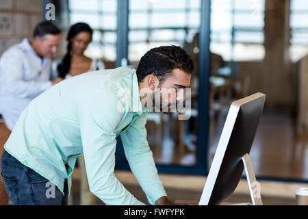 Junger Mann am Computer arbeiten Stockfoto