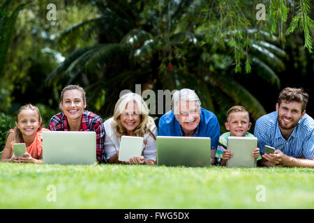 Porträt der Familie mit Technologien liegen am Hof Stockfoto