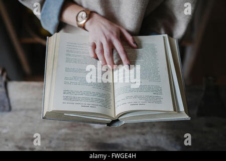 Eine Frau liest aus einem Rezeptbuch in einer Küche. Stockfoto