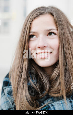 Eine junge Frau in einem Tartan-Karo-Schal im Freien im Winter. Stockfoto