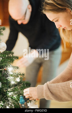 Vater und Tochter einen Weihnachtsbaum zu verzieren. Stockfoto