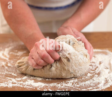 Kneten den Teig auf einer bemehlten Fläche. Stockfoto