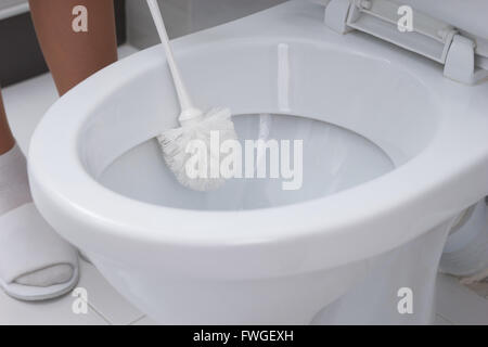 Frau, Reinigung eine WC-Schüssel mit einem Pinsel in einer Nahaufnahme konzeptionelle Haushalt Hygiene und Sauberkeit Stockfoto