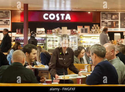 Costa Coffee Mitarbeiter Kellnerin serviert Kaffee und Lebensmittel, Costa Coffee, South Mimms Autobahn Tankstelle, M25, London UK Stockfoto