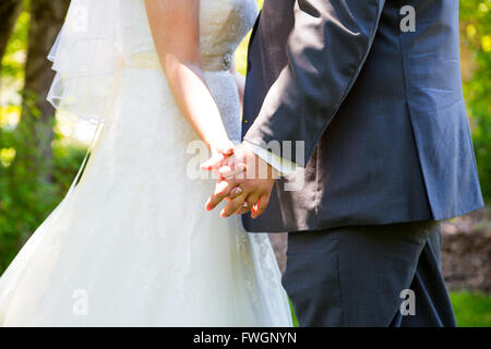 Diese Braut und Bräutigam halten Hände romantisch beim Küssen am Tag ihrer Hochzeit. Stockfoto