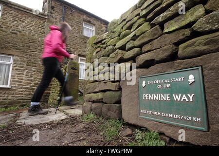 Eine weibliche Walker geht die Zeichen am offiziellen Startpunkt der Pennine Way National Trail Edale, Peak Distrikt, UK Stockfoto