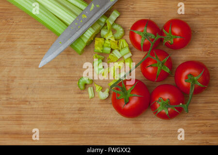 Sellerie und Tomaten auf einem Schneidebrett Stockfoto