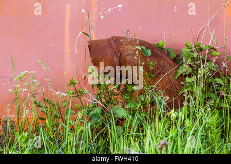 Rostige Rohr auf Hintergrund der alten roten garage Stockfoto