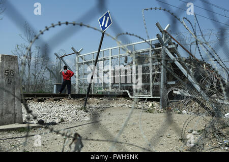 Idomeni, Griechenland. 4. April 2016. Ein Junge steht vor dem Zaun von der mazedonischen Polizei gestellt. Migranten und Flüchtlinge in einem provisorischen Lager an den griechischen Dorf Idomeni, in der Nähe der griechisch-mazedonischen Grenze. 52.451 Flüchtlinge und Migranten insgesamt sind in Griechenland, mehr als 11.000 am Idomeni, nach dem Abkommen zwischen der EU und der Türkei am 20. März. © Panayiotis Tzamaros/Pacific Press/Alamy Live-Nachrichten Stockfoto