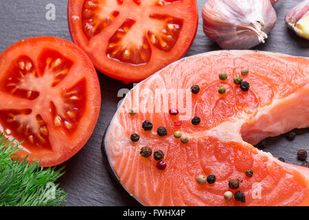 roter Fisch Steak mit Tomaten auf Schiefer Tisch. Stockfoto