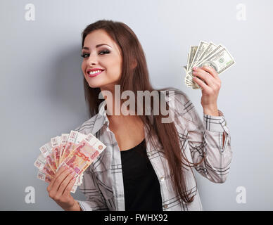 Glücklich Geschäftsfrau Denken dieser Währung zu wählen, Dollar oder Rubel und die Wahl Dollar Geld in verschiedenen Händen hält. Stockfoto