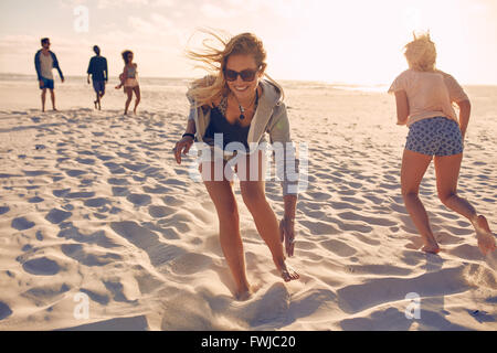 Junge Frauen Rennen am Strand. Gruppe von Jugendlichen, die an einem Sommertag am Sandstrand spielen. Spaß auf der bea Stockfoto