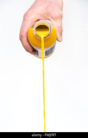 Hand strömenden Orange Frucht Smoothie trinken aus einer Flasche vor weißem Hintergrund Stockfoto