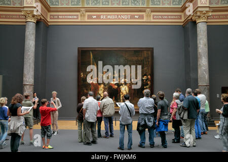 Besucher stehen vor "die Nachtwache" (1642) von Rembrandt van Rijn im Rijksmuseum, Amsterdam, Niederlande. Stockfoto