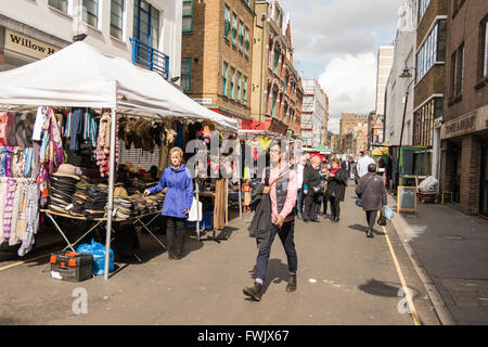 Eine junge Frau geht den Leather Lane Street Market im Zentrum von London, England, Großbritannien, entlang. Stockfoto