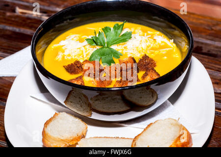 Vegetarische Kürbissuppe mit Petersilie, Croutons und geriebenem Käse Stockfoto