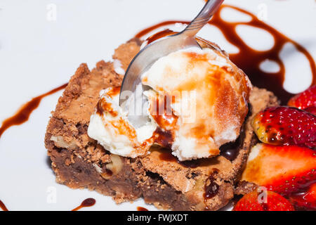 Löffel stecken In Brownie mit Eis und Erdbeeren, köstliches Dessert Stockfoto