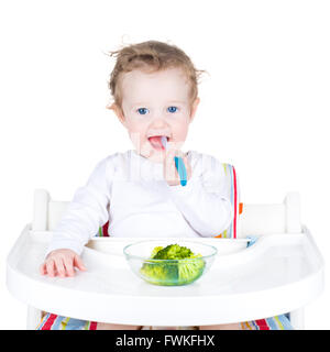 Süße kleine Baby Essen Brokkoli, isoliert auf weiss Stockfoto