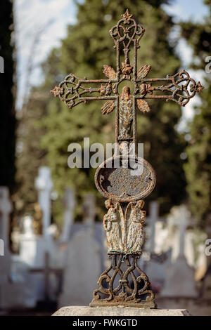 Alte rostige Eisernes Kreuz mit Jungfrau Maria und zwei Engel auf dem Friedhof del Carmen, Valladolid, Kastilien und Leon, Spanien. Stockfoto