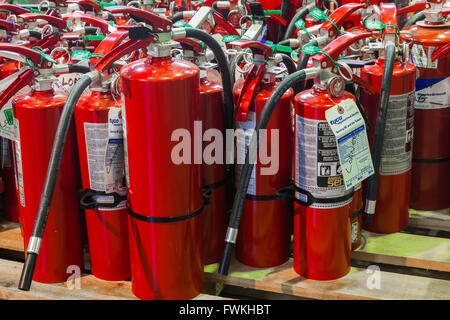 Mehrere Größen von Feuerlöschern auf einer Holzpalette warten auf die Bereitstellung Stockfoto