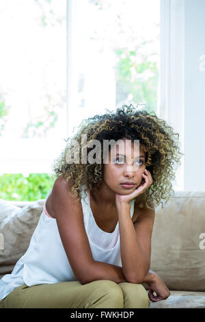 Gespannten Frau sitzt am Bett im Wohnzimmer Stockfoto