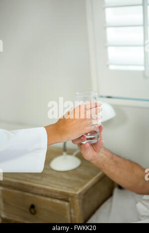 Bild des Arztes geben Wasser für ältere Patienten zugeschnitten Stockfoto