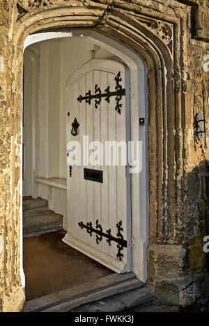 Antiker gewölbter Eingang mit kunstvoller Flügeltür und geschnitzter Steinumrandung. Banbury historische Stadt England Großbritannien Stockfoto