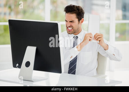Frustriert Geschäftsmann hält Tastatur im Zorn Stockfoto