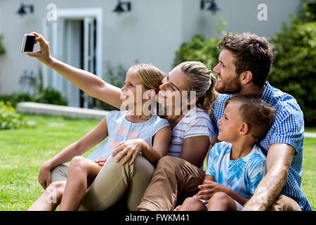 Glückliche Mutter nehmen Selfie mit Familie in Hof Stockfoto