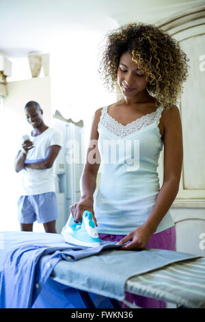 Junge Frau ein Hemd bügeln in der Küche Stockfoto