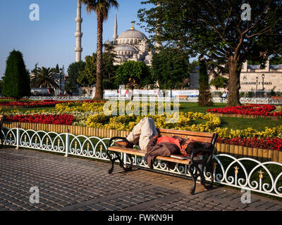 Obdachloser schlafen morgen auf Bank im Park vor der blauen Moschee (Sultan Ahmed Mosque) in Istanbul, Türkei Stockfoto