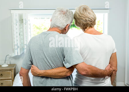 Ansicht der Rückseite des Senior Paar stehend gegen Fenster Stockfoto