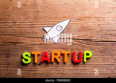 Schreibtisch mit Start-up-Zeichen und Papier-Rakete. Stockfoto