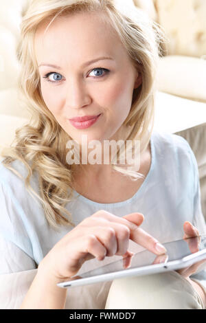 Abbildung einer jungen, schönen Blondine mit einem digital-Tablette, die Frau berührt den Bildschirm, Frau mit Tablet Touch. Stockfoto