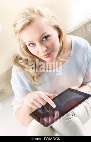 Abbildung einer jungen, schönen Blondine mit einem digital-Tablette, die Frau berührt den Bildschirm, Frau mit Tablet Touch. Stockfoto