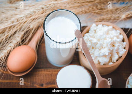 Natürliche selbstgemachte Produkte: Milch, Käse, Sauerrahm und Eiern auf den alten hölzernen Hintergrund mit Ähren. mit Platz für Ihre te Stockfoto