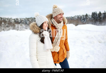 glückliches Paar zu Fuß über Winter Hintergrund Stockfoto